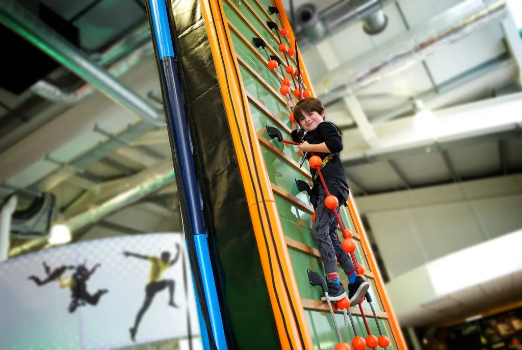 A 6 year old boy climbing a wall