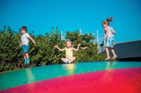 Children playing on the Jumping Pillows activity