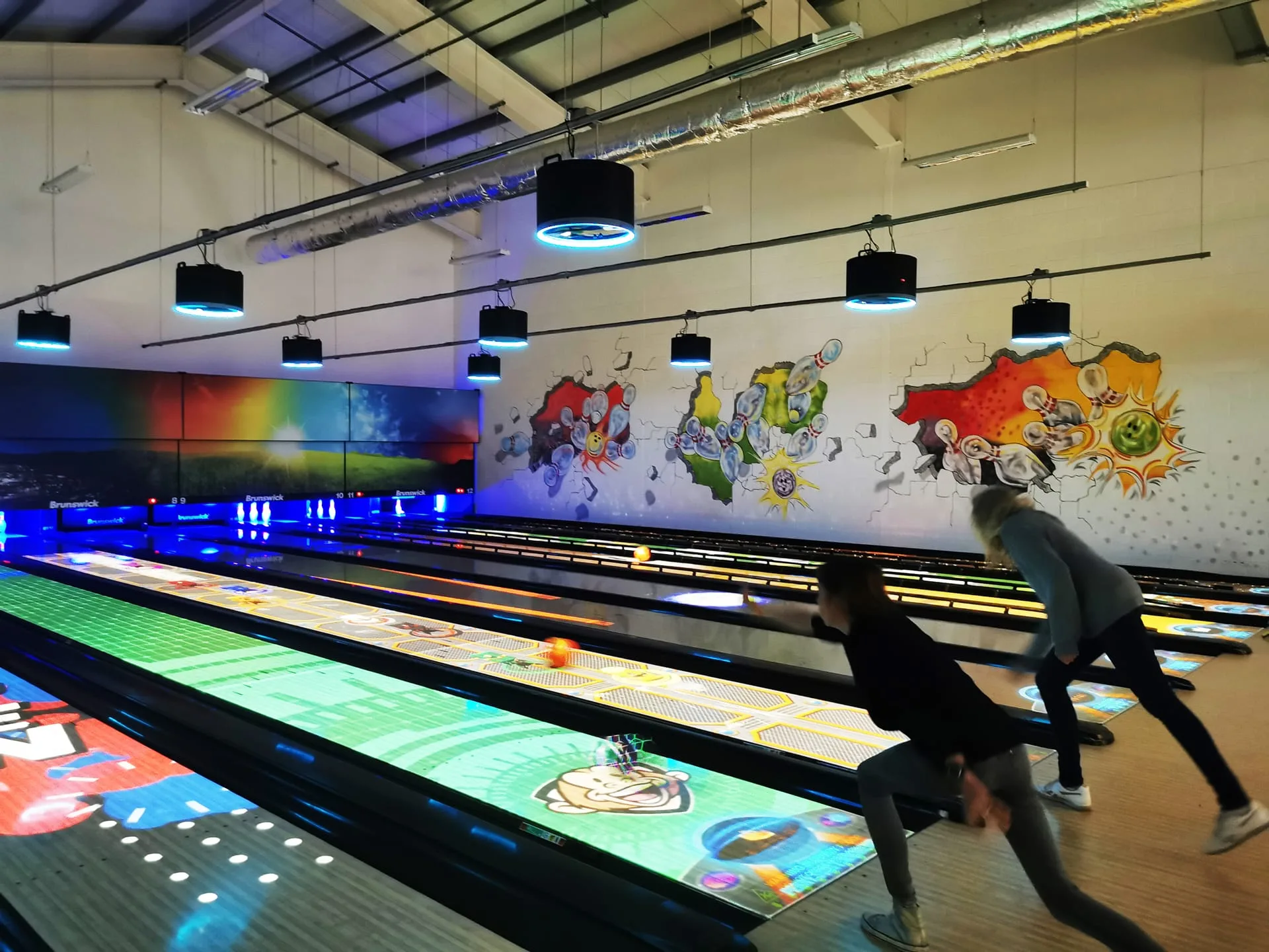 Adults bowling on hte interactive bowling alley