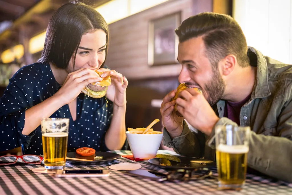 Adults eating burgers and chips